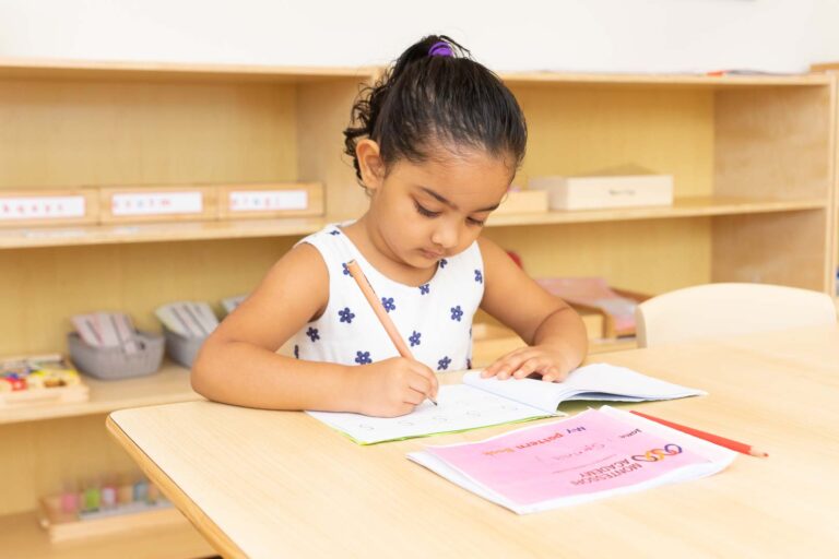 Preschool child writing in a booklet