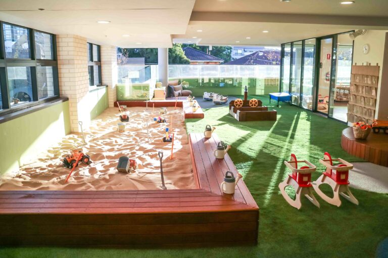 Childcare Playground with large sandpit, rocking chairs, and wooden ship