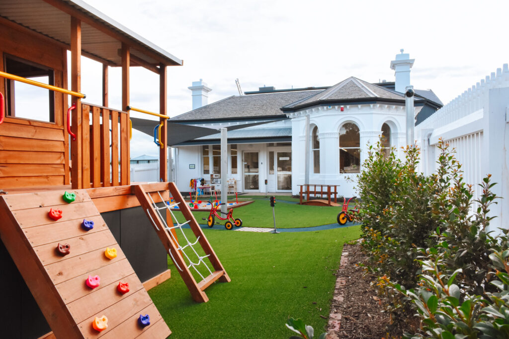 Childcare outdoor playground with sandpit, cubby house, bike track and tricycles