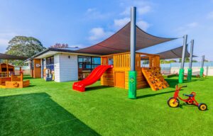 Childcare outdoor playground with play equipment, tricycles, shade sails and sandpit