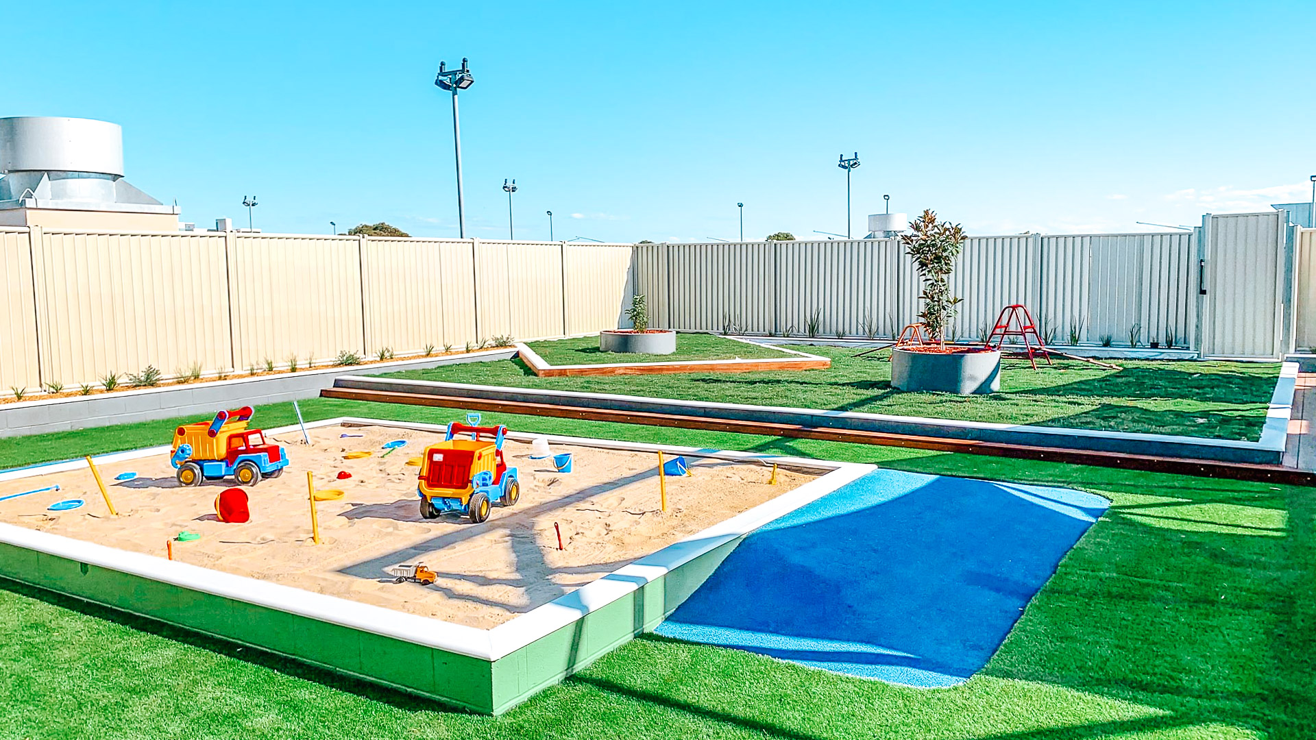 Childcare outdoor area with sandpit and climbing frame