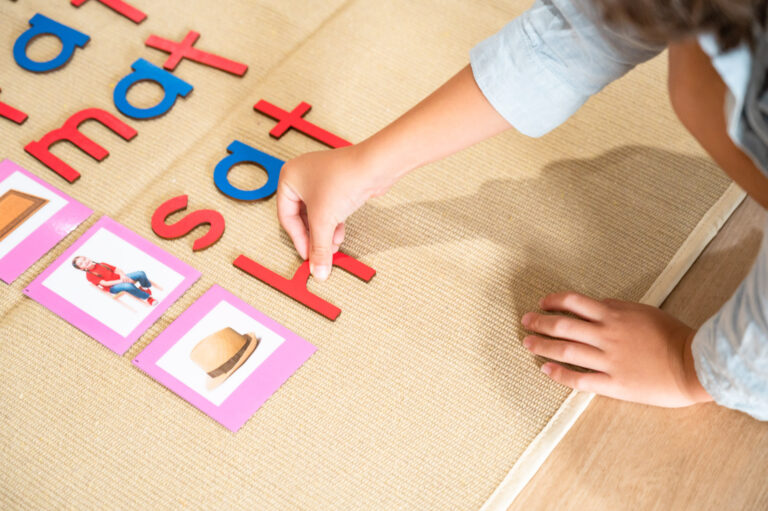 Child completing the moveable alphabet to spell
