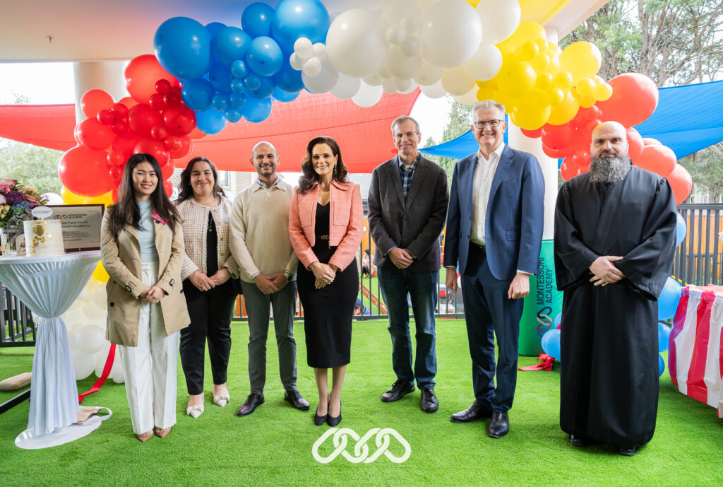 Senior community leaders stand together under balloon arch at the grand opening of a Montessori childcare centre in Condell Park, NSW.