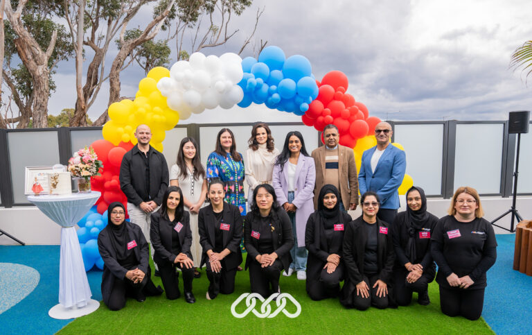 Leadership, community leaders and Bexley team pose for photograph in front of balloon arch at Bexley Montessori Academy grand opening