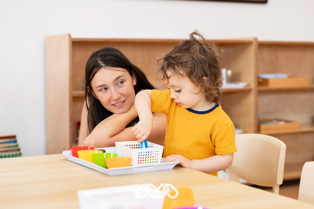 Child enjoys Montessori colour sorting activity at Penrith Derby Street grand opening event in preschool classroom.